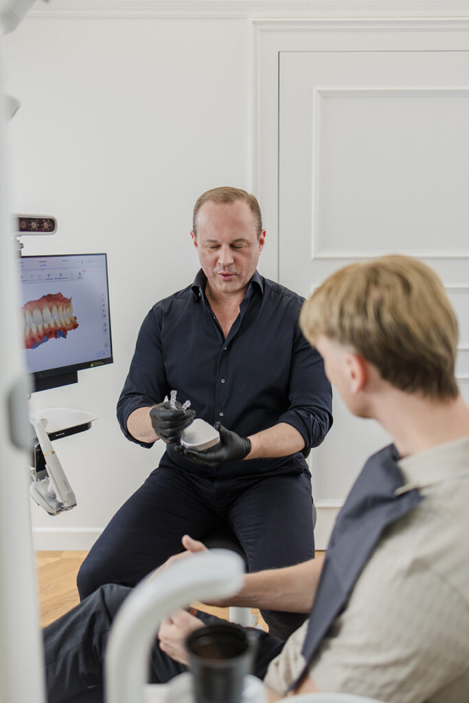 Herr Stoll berät einen Patienten über ästhetische Zahnmedizin